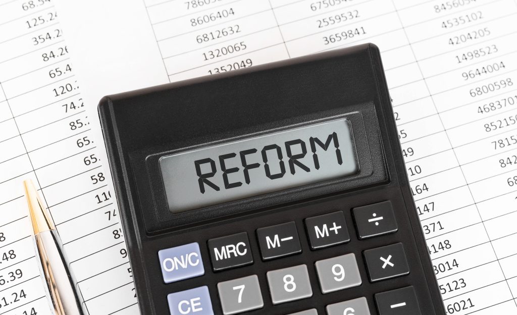 Calculator with the word reform highlighting economic and tax policy debates.
