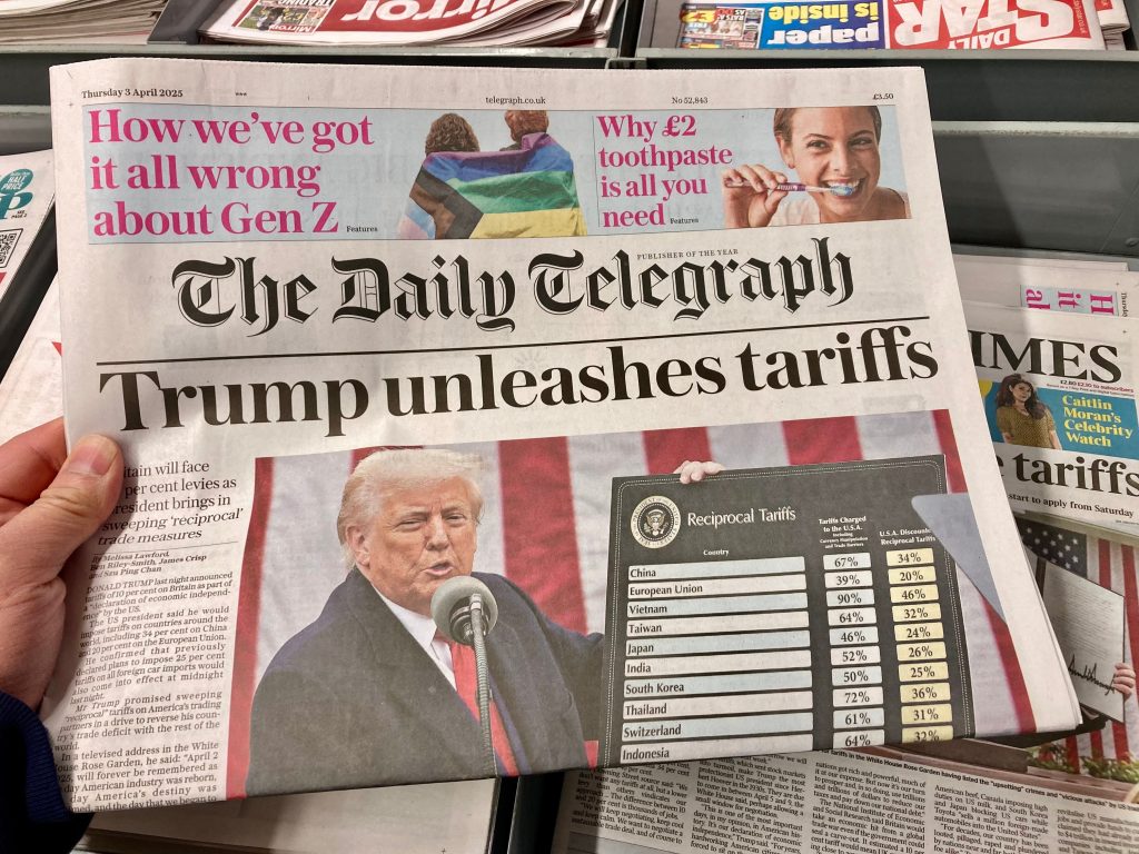 Newspaper headline on Trump imposing sweeping tariffs on multiple countries.