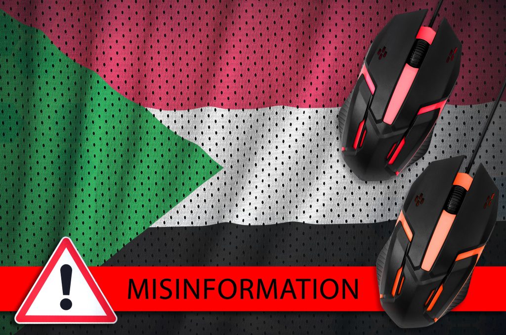 Sudan’s flag with a misinformation warning illustrates how digital manipulation and foreign influence distort understanding of Sudan’s war.