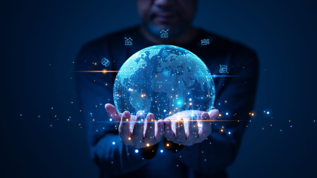 A person holding a glowing digital globe representing global cybersecurity, data flows and interconnected systems in a dark technological environment.