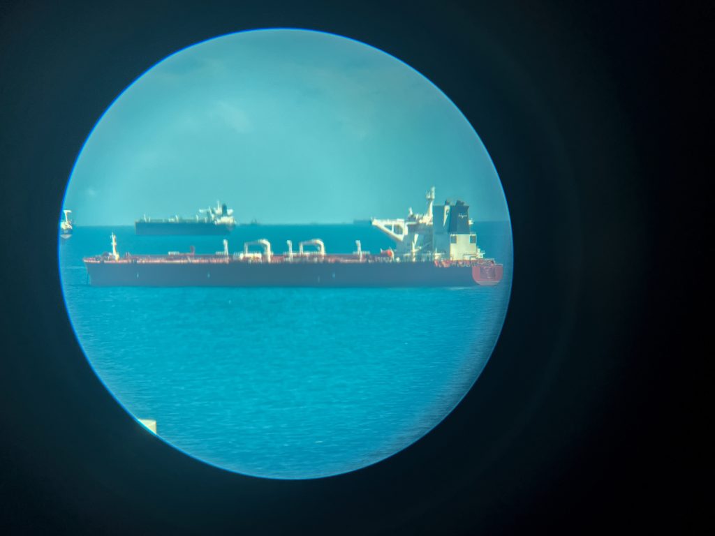 A tanker vessel with no visible identification marks, possibly a symbol of the so-called "shadow" or "sanction fleet", photographed through an optical device