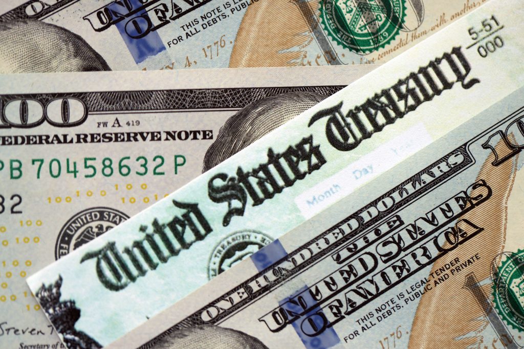 US dollar banknotes and US Treasury note text, illustrating sovereign debt, financial sanctions, and global monetary power
