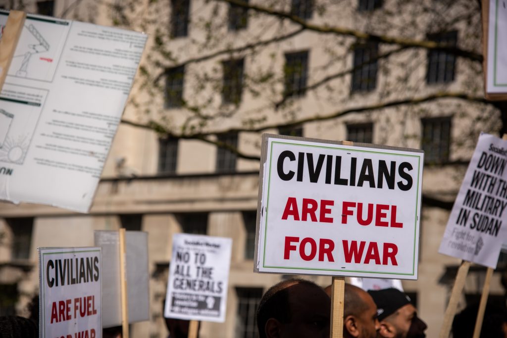 Protest sign reading “Civilians Are Fuel for War” during demonstration on Sudan conflict and humanitarian emergency