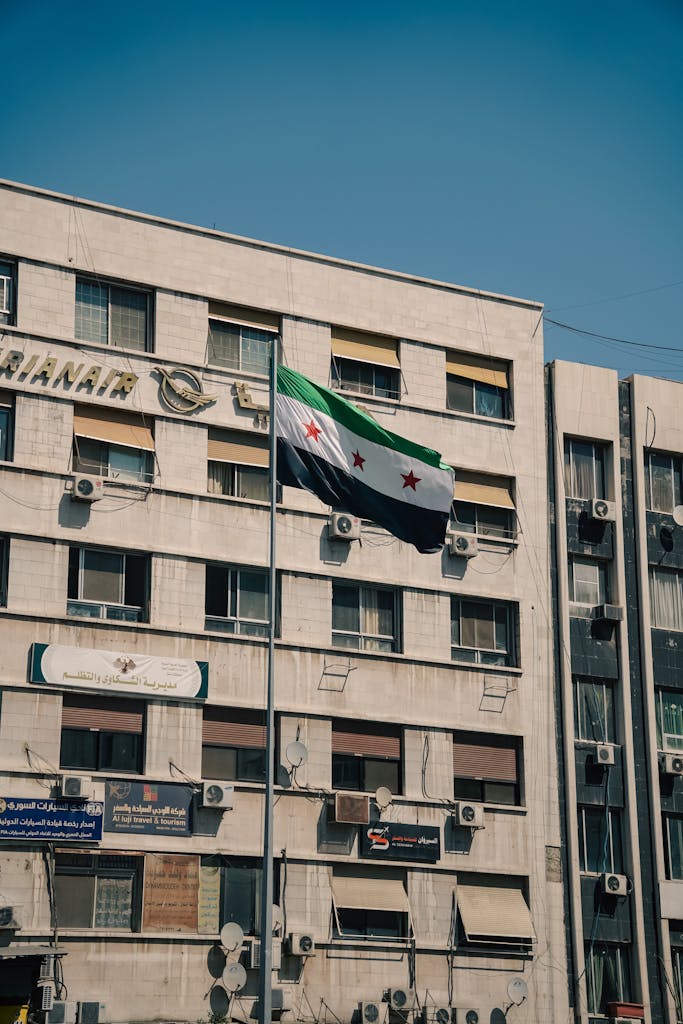 The Syrian flag waves on a historic building in Damascus.