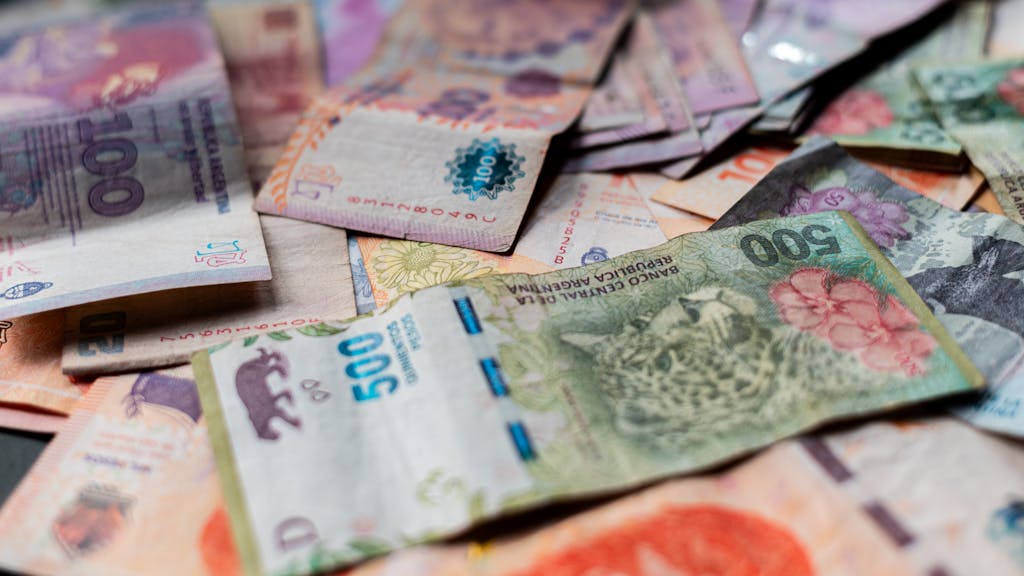 A detailed image showcasing various Argentine peso banknotes in vivid colors.