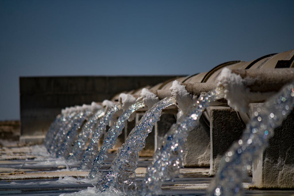 Close-up view of water flowing from industrial pipes.