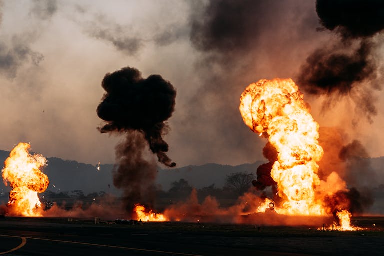 Intense fireball explosions with thick smoke in an outdoor setting.