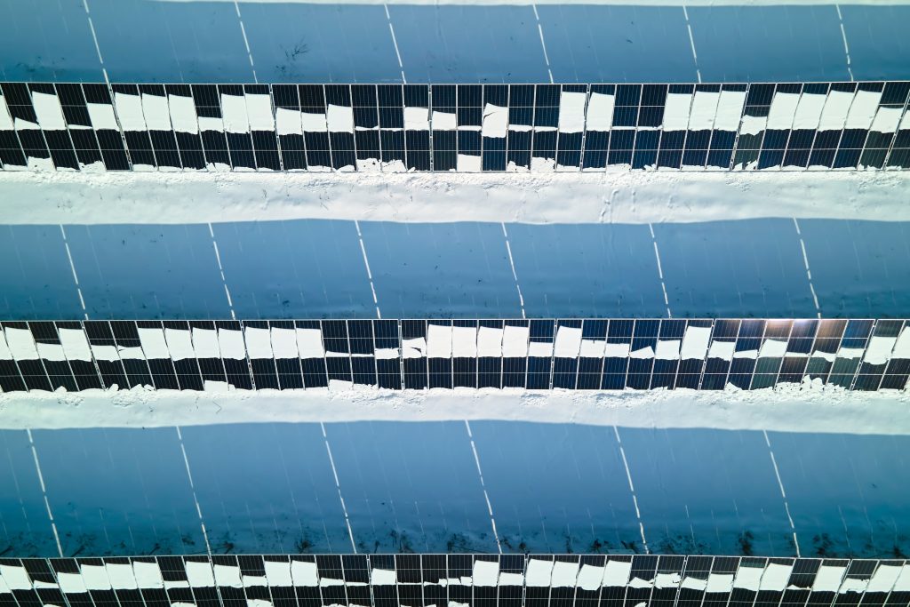 Snow-covered solar panels illustrating climate impact on energy infrastructure and resilience in extreme environmental conditions