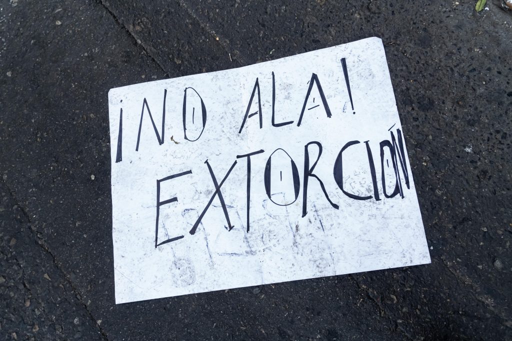 Handwritten sign reading “No a la extorsión” on pavement highlighting public resistance to extortion in Mexico