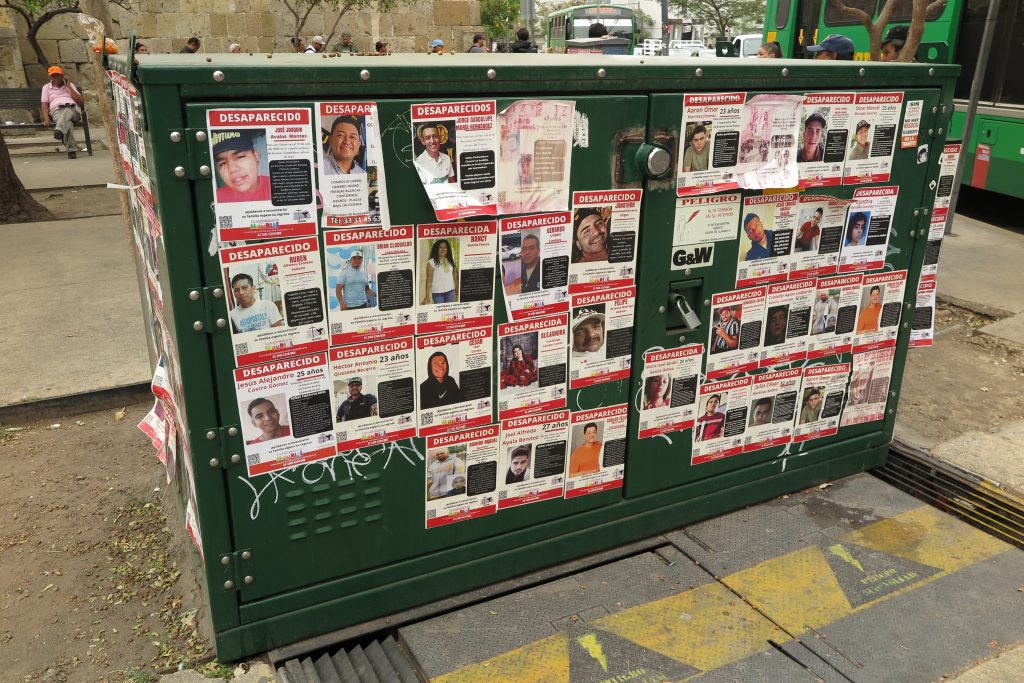 Wall covered in missing persons posters in Mexico highlighting disappearances linked to organised crime and violence