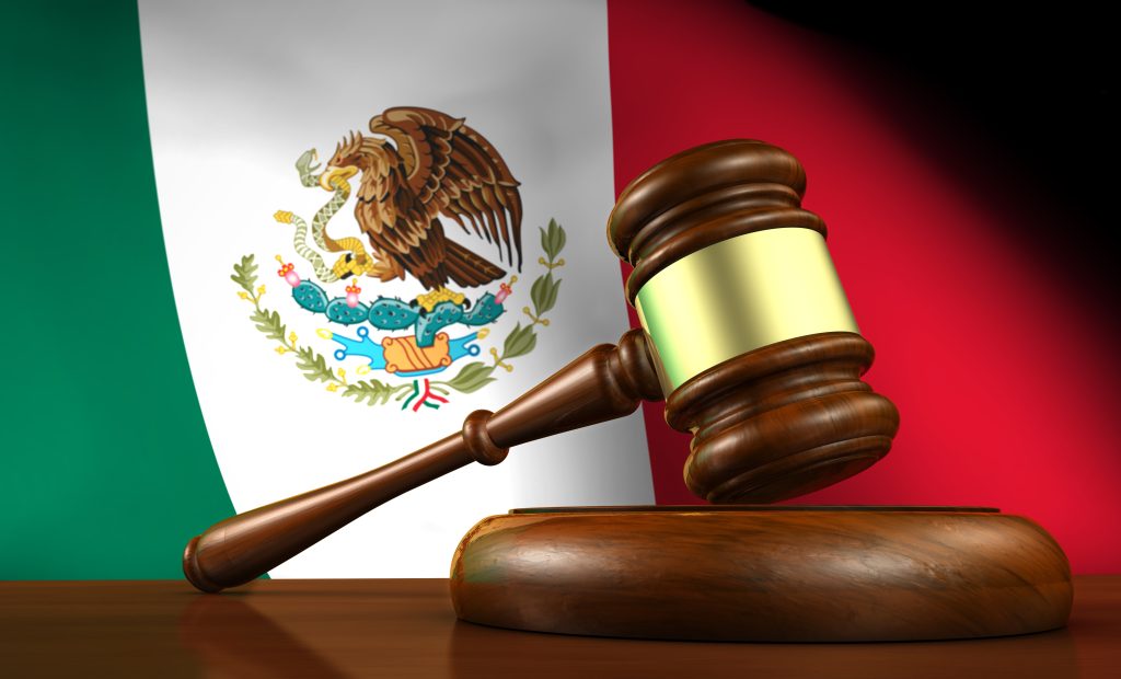 Judge’s gavel in front of Mexican flag symbolising law enforcement, justice system, and rule of law in Mexico