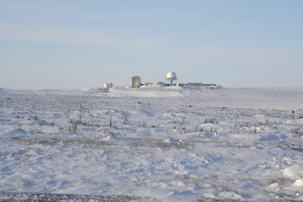 Remote Arctic early warning radar station in snowy landscape illustrating climate impact on defence infrastructure and strategic stability