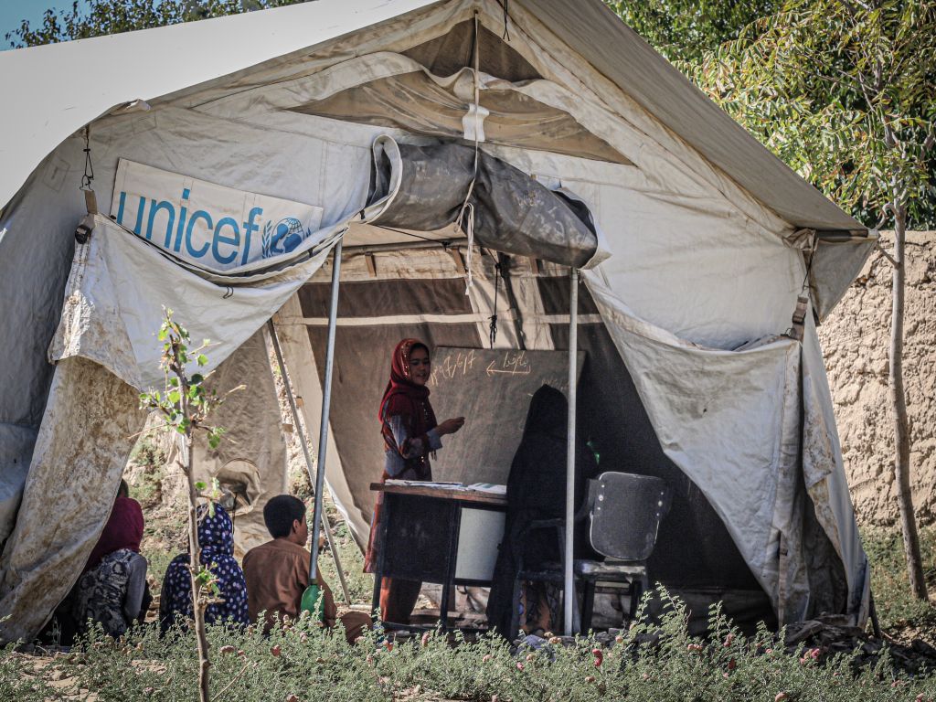 Children attending class in a UNICEF tent in Afghanistan refugee camp.